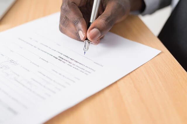 A man signing a contract for IT solutions, such as mobile app and web development.